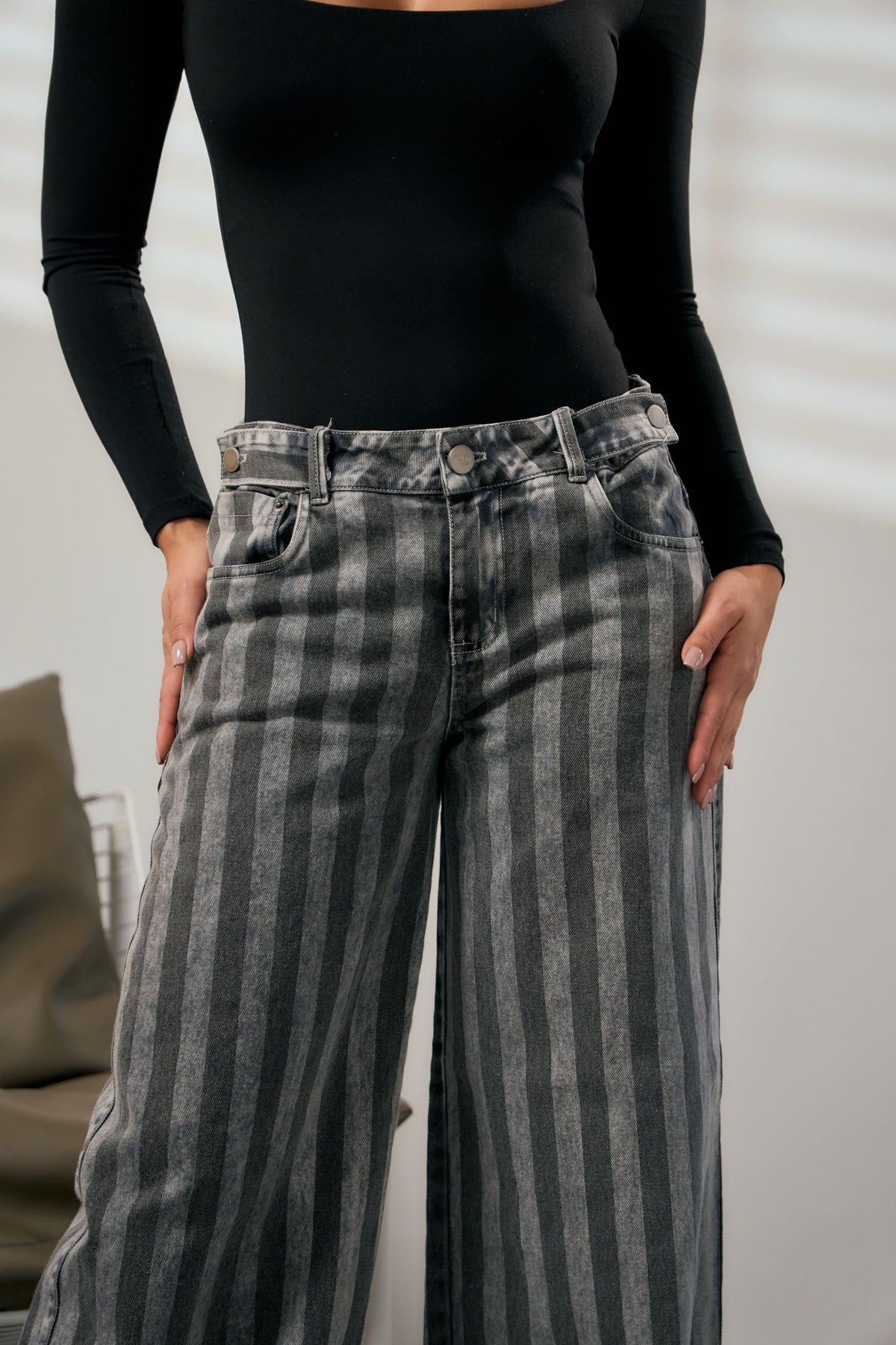 Detalle de las rayas en contraste del jean wide leg negro