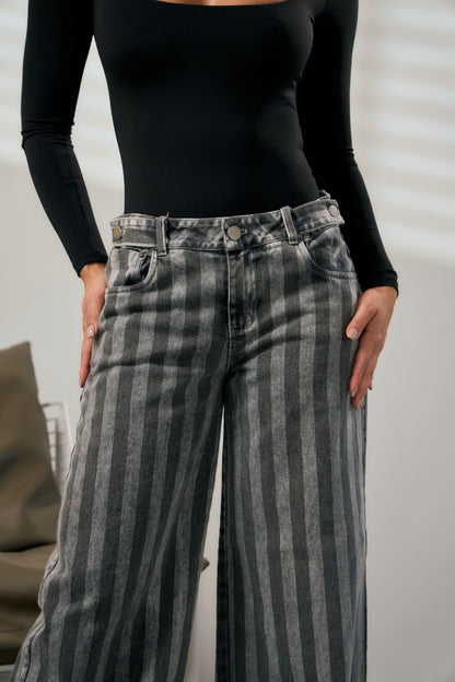 Detalle de las rayas en contraste del jean wide leg negro